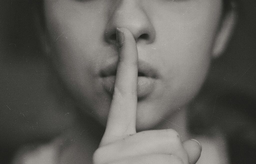 Woman placing finger over closed lips