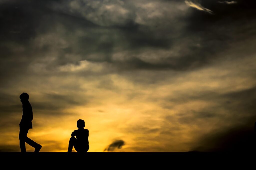 Sunset backdrop with two silhouettes in foreground