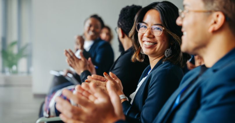 International professionals applauding a speaker